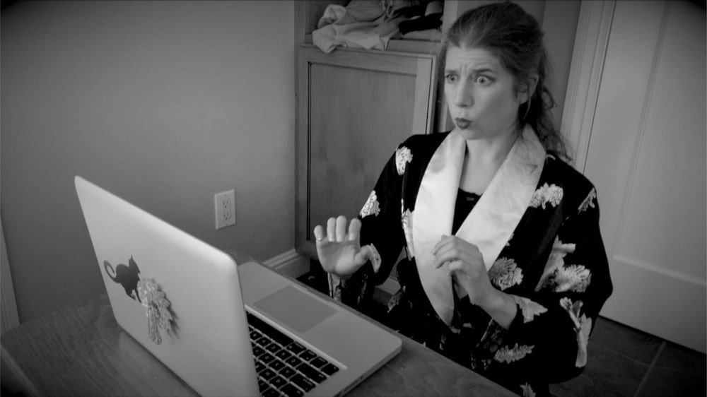 fotografia: kobieta w szlafroku siedzi w mieszkaniu przed laptopem