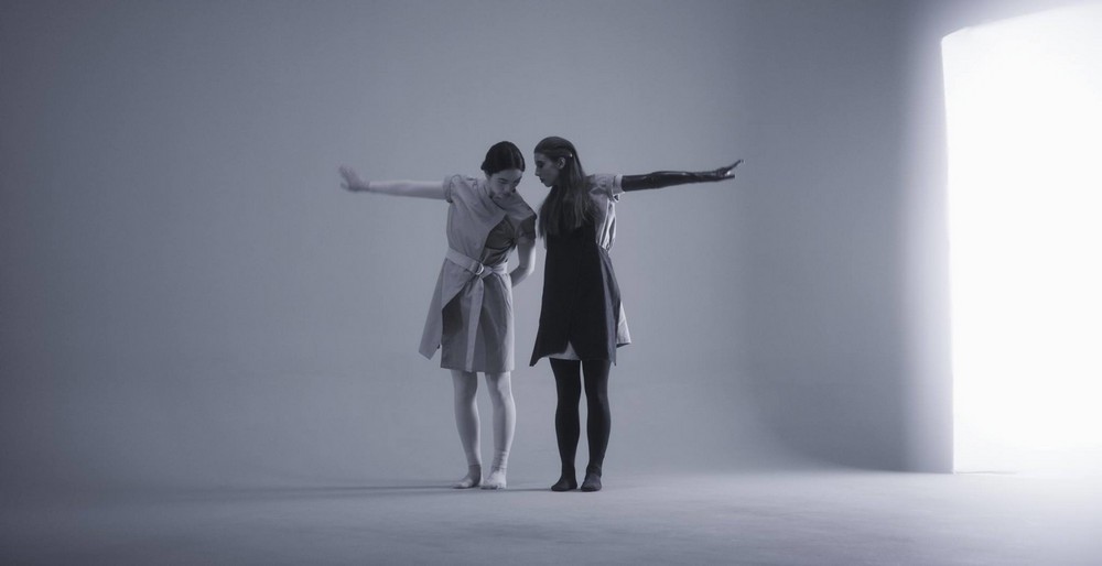 fotografia: tancerze, kobieta i mężczyzna stoją obok siebie, każde ma wyciągniętą jedną ręke