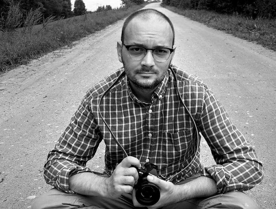 fotografia: filip springer z aparatem fotograficznym na tle drogi