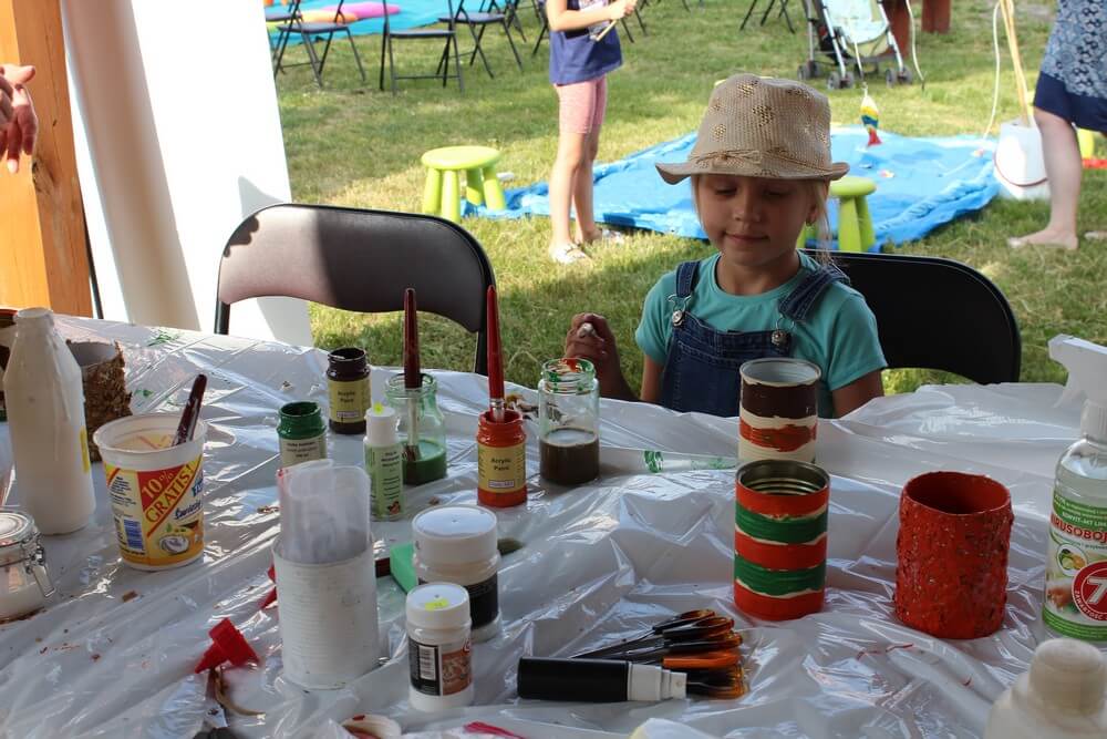 fotografia: dziewczynka siedzi przy stoliku z farbami Karawana Wędrujący Festiwal Sztuki i Animacji