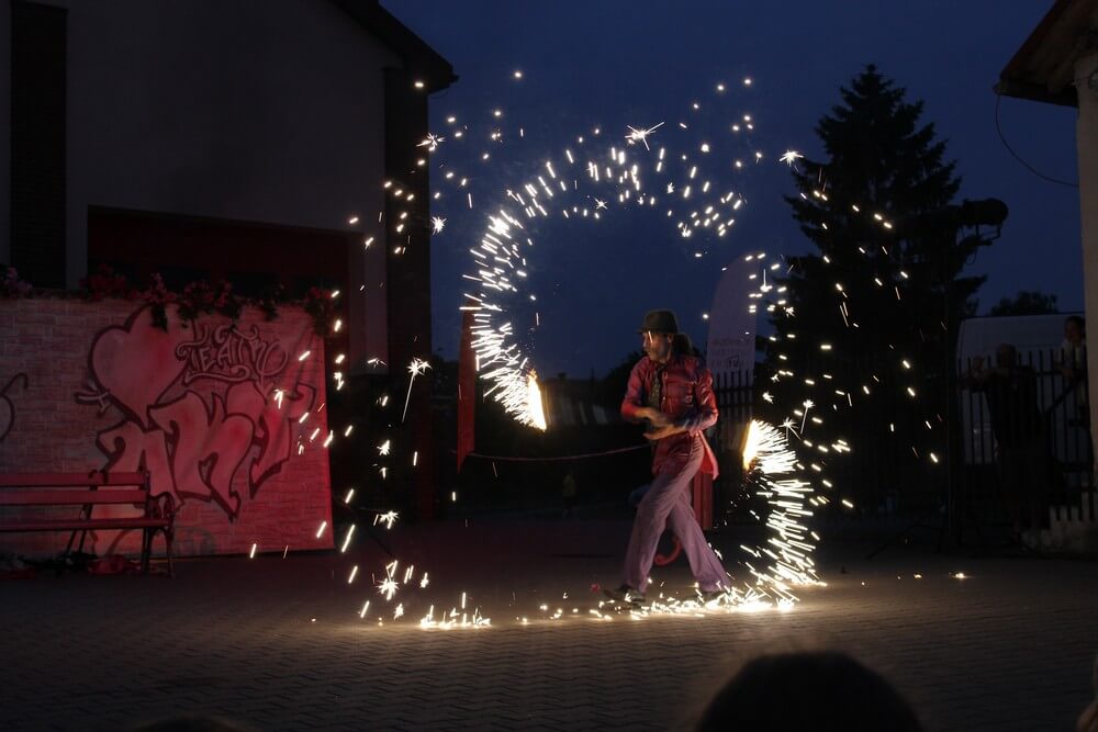 fotografia: aktor teatru akt w ciemnościach używa efektów pirotechnicznych Karawana Wędrujący Festiwal Sztuki i Animacji