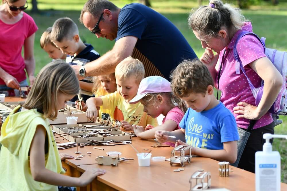 fotografia: grupa dzieci przy stole, składa konstrukcje z elementów