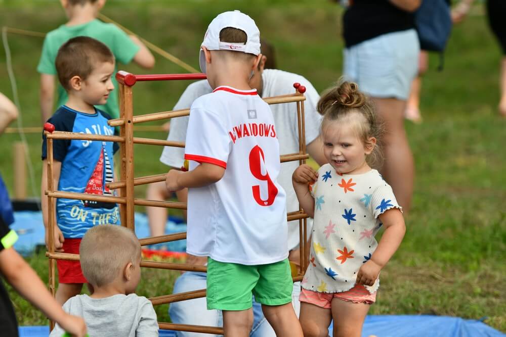 fotografia: grupa dzieci składa drewnianą konstrukcję