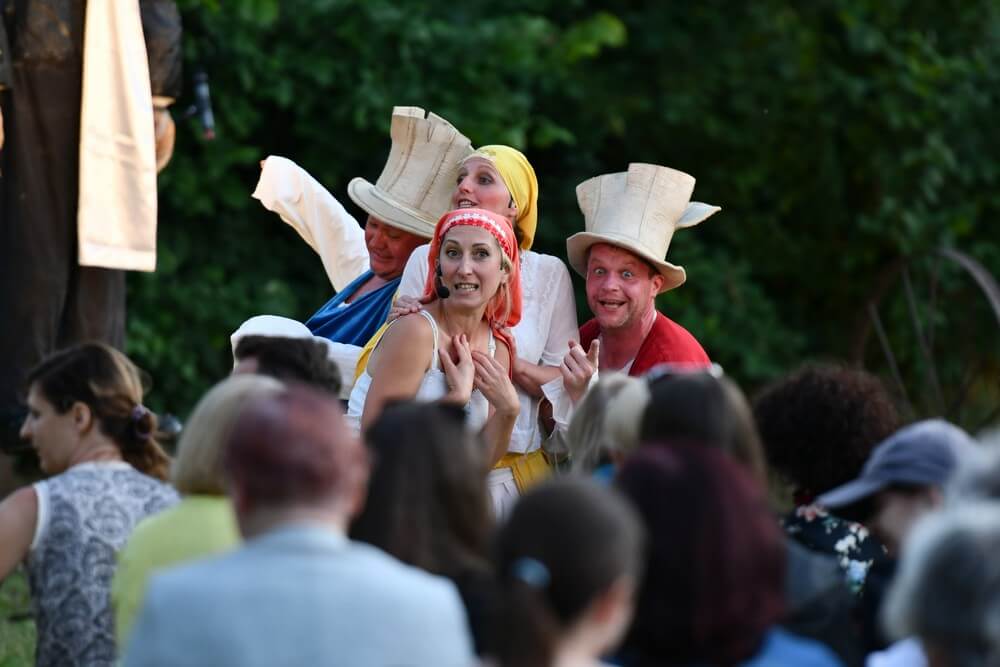 fotografia: grupa aktorów w trakcie spektaklu, na pierwszym planie publiczność