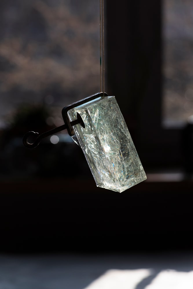 fotografia: sześcienna bryła szkła zawieszona na sznurku
