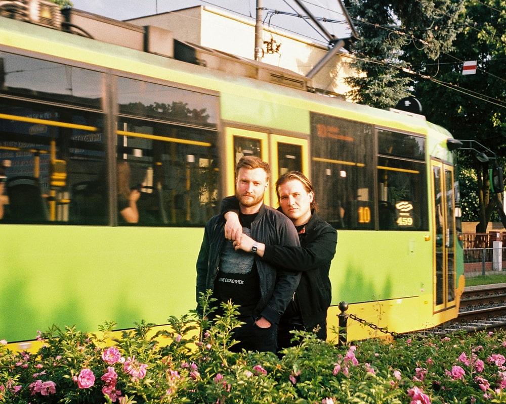 fotografia: dwóch mężczyzn stoi na tle tramwaju