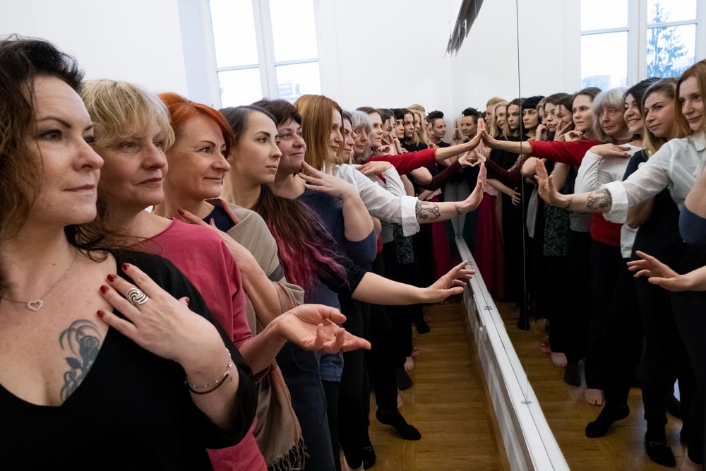 fotografia: grupa kobiet stojąca w rzędzie na przeciwko lustra w sali do ćwiczeń baletowych