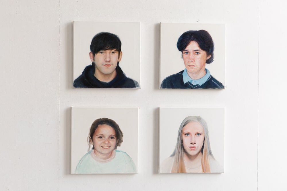 fotografia cztery portrety ludzkich twarzy wiszące obok siebie