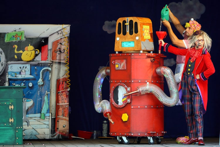 fotografia dwoje aktorów i duży obiekt przedstawiający robota