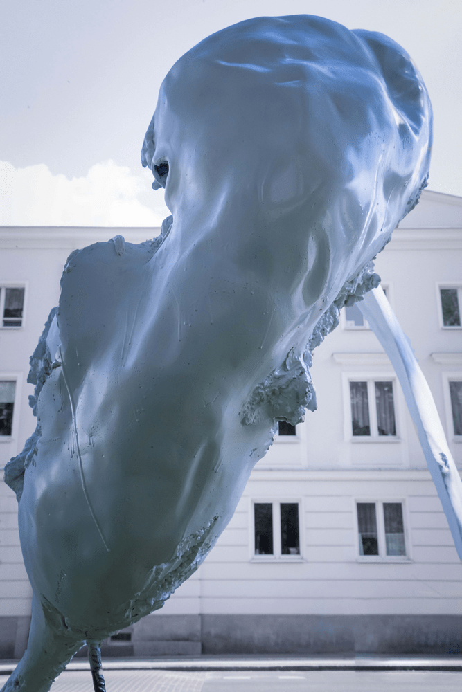 fotografia fragment rzeźby abstrakcyjnej na tle białego budynku