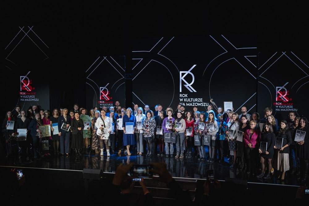 fotografia grupa kilkudziesięciu osób laureatów nagród na scenie