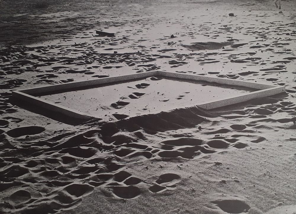 reprodukcja grafiki przedstawiającej piasek i prostokątne obramowanie w piastku