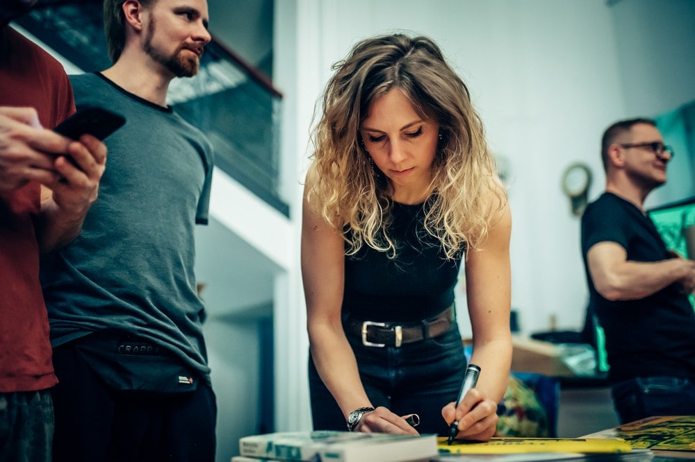 fotografia kobieta składa autograf na plakacie