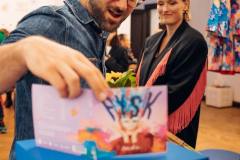 fotografia - mężczyzna ogląda okładkę płyty cd bovskiej. w głębi stoi bovska