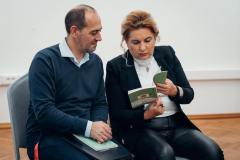 fotografia - norbert późniewski i dyrektor izabela bednarczyk siedzą obok siebie i przeglądają książkę