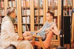 fotografia: dwie osoby rozmawiają w bibliotece