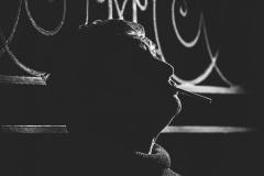 fotografia czarno biała: marcin świetlicki w półmroku, trzyma w ustach papierosa